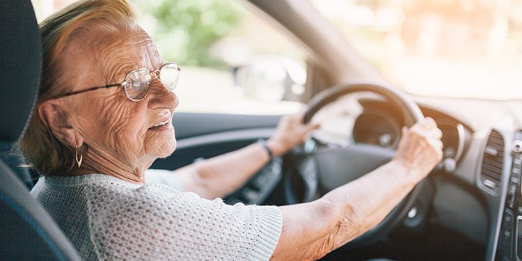 Elderly woman behind the steering wheel Envida opfriscursus